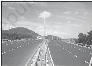 A divided national highway in India with vehicles moving in separate lanes, illustrating highway construction for unobstructed movement