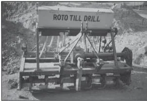 A roto till drill machine working in a field, combining soil preparation and seed sowing in one pass